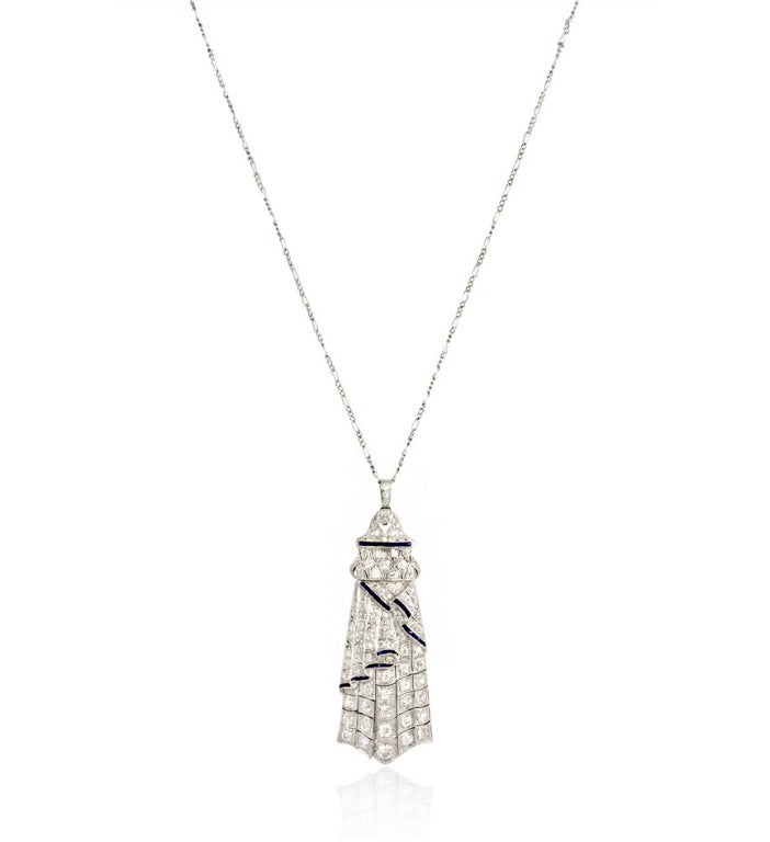 An Art Deco sautoir comprised of a diamond chain suspending a synthetic sapphire and diamond pendant, in platinum. Approximate total diamond weight, including chain 5.08 carats.