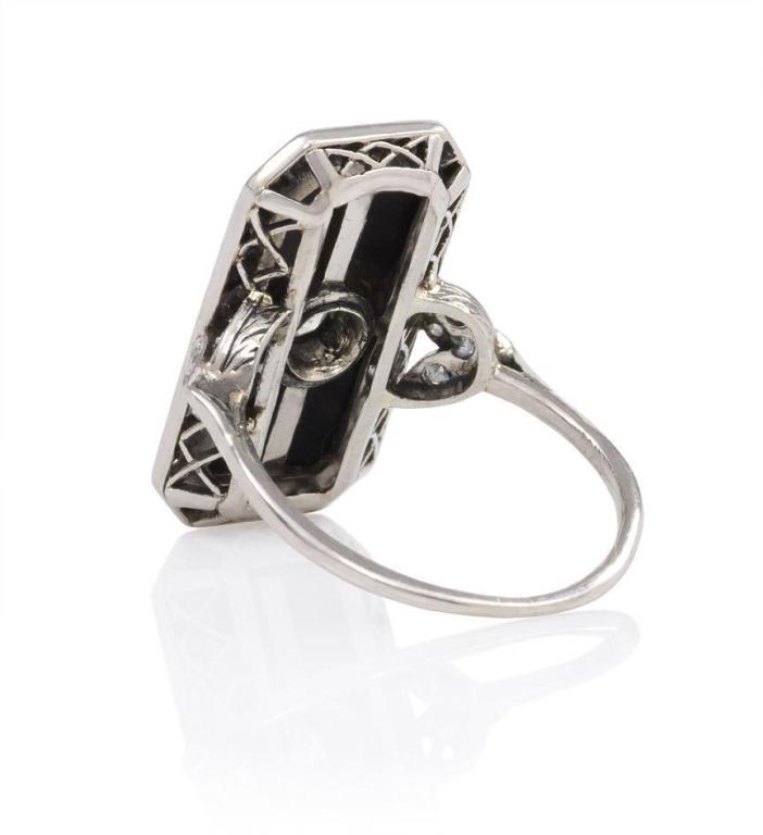 An Edwardian ring with a rectangular diamond-set onyx plaque in a rose diamond surround with foliate shoulders, in platinum.  Atw 1.15 ct.