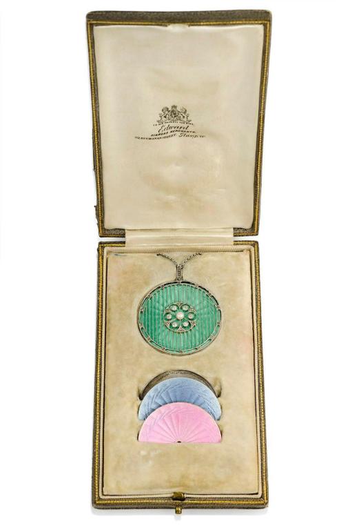 An Edwardian circular diamond and pearl pendant with vertical knifewire and four interchangeable engine-turned enamel inserts in blue, pink, black and green, in platinum.