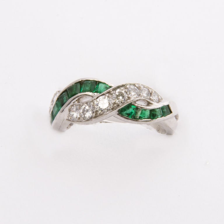 Platinum mount Oscar Heyman intertwined design emerald and diamond top band, bead set with 11 round brilliant cut diamonds totaling approx..55 cts.and channel set with 12 square cut natural emeralds, size 6 1/4, may be sized slightly hallmarked and