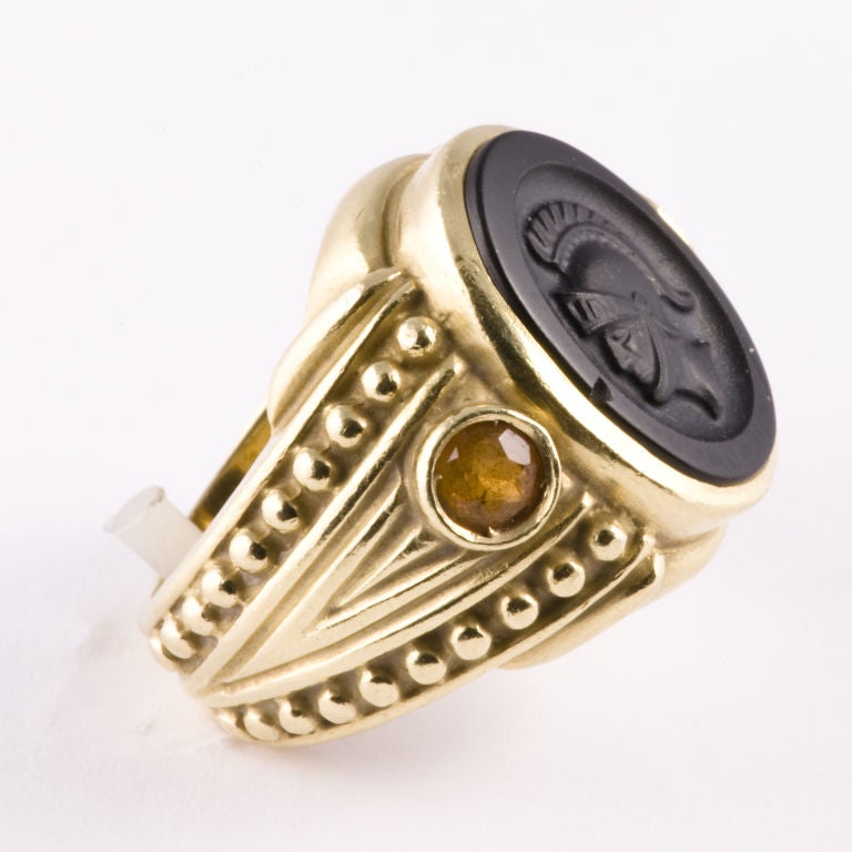 18kt. yellow gold onyx intaglio center ring, bezel set on each side with a round faceted natural citrine,size 5 1/2, may be sized slightly