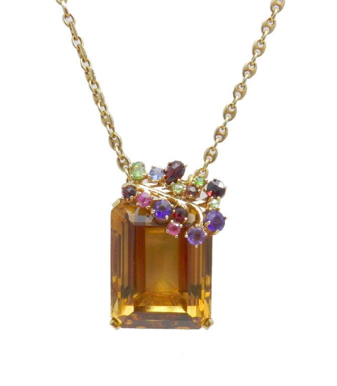 Handmade 14kt. yellow gold  large rectangular faceted citrine pendant weighing approx. 90 cts. prong set with a graceful branch of amethyst, pink and blue sapphire garnet and peridot. The chain bales are hidden at the back.