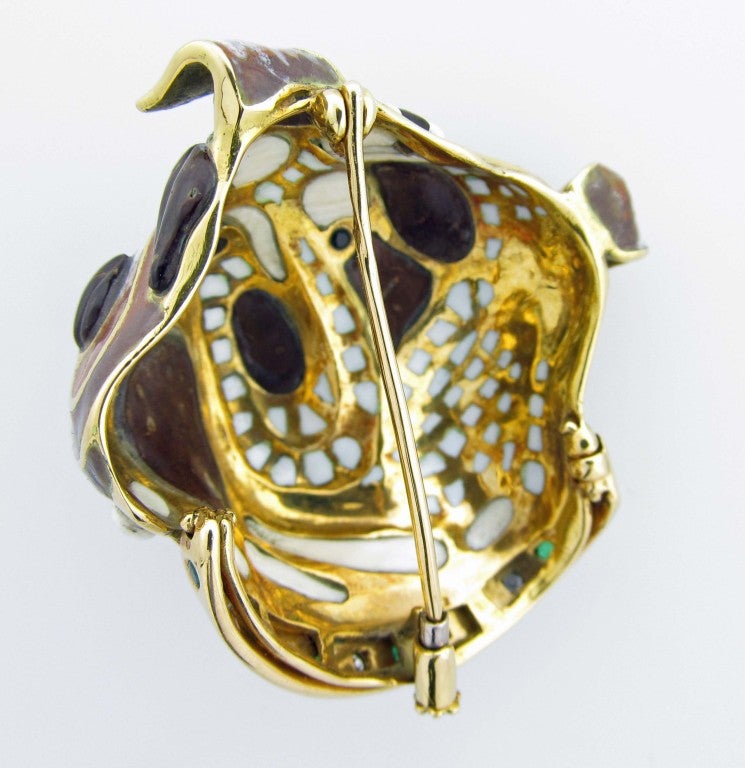 18kt. yellow gold dimensional enamel bulldog brooch with a collar that is bead set with 7 round faceted natural emeralds and 6 round brilliant cut diamonds.