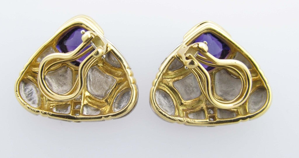 Handmade mixed metal platinum and 18kt. yellow gold earrings in a winged design. Each earring is set with sugarloaf shape natural rich amethyst and bead set with 5 round brilliant cut diamonds totaling approx..25cts. Clip back, posts may be added.