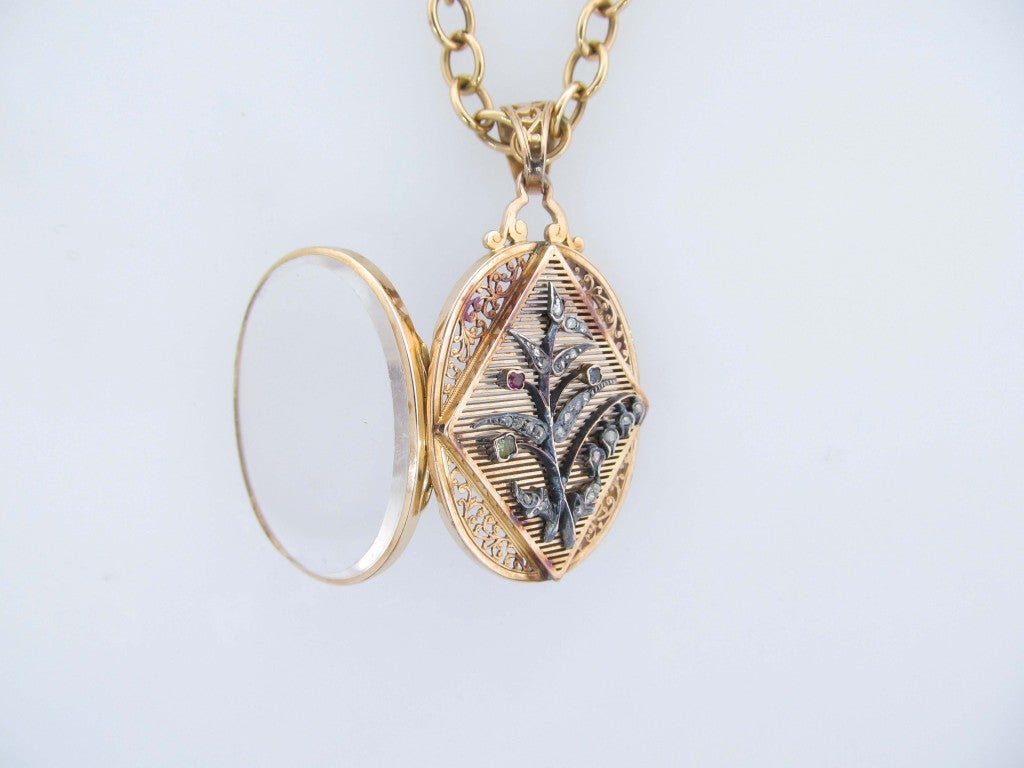 Absolutely beautiful 18kt. rose gold open work locket set with rose cut diamonds, ruby, sapphire and beryl in a floral motif. The locket is all original and in marvelous condition. The 15