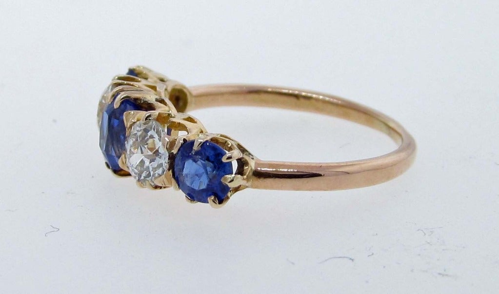Beautiful antique 18kt. yellow gold band prong set with 3 old cut Ceylon color natural sapphires totaling approx.  1.3cts.  and 2 old mine cut diamonds totaling approx.80cts. all of which are of fine quality size 6 1/2 and may be sized circa 1880.