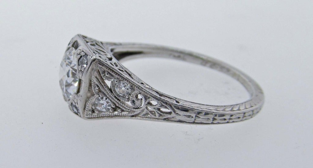 Handmade platinum Art Deco diamond ring bead set in the center with a round European cut diamond weighing approx..75cts. grading VS clarity H color. The detailed open work engraved mount is bead set around the center and on the shank with 8 round