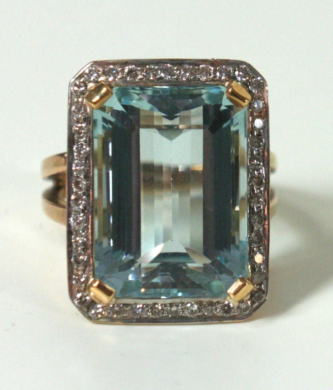 Large deep emerald-cut Aquamarine stone set in 18 kt gold surrounded with diamonds