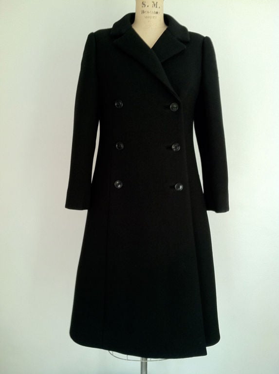 A fine and rare vintage Givenchy haute couture coat. Authentic black woven wool item fully silk lined. Item features double breasted button front, hidden side pockets & precision seams. Excellent.