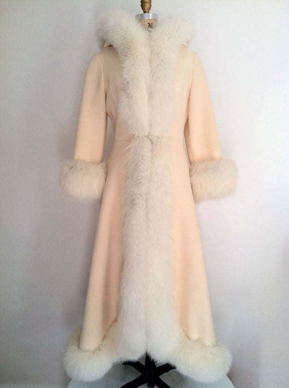 Fine vintage fox fur trimmed maxi coat. Authentic cream wool fabric item fully trimmed in silver fox fur. Item features hidden snap & hook front closures & lined hood.