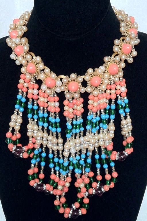 Fine and rare vintage William de Lillo bib necklace. Signed gilt metal item set with genuine coral cabochons with beaded fringed front (faux coral, turquoise, emerald, pearls and Swarovski crystals). An outstanding and dynamic item appropriate for