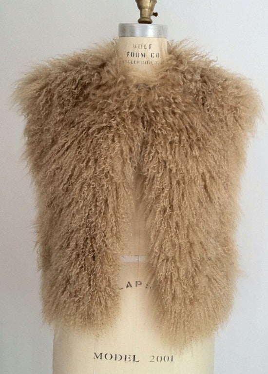 Fine vintage Mongolian curly lamb fur vest. Sleeveless 'mocha' dyed fur item fully silk lined with hidden side pockets. Item features single hook closure at neck.