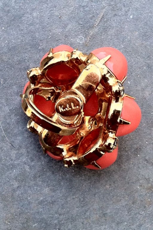 A vintage Kenneth Jay Lane 'jeweled' dome ring. Signed (KJL) gilt metal item set with faux coral cabochons and crystal. Adjustable band one size all.

*Please contact dealer to purchase with free FedEx overnight shipping or with any questions.