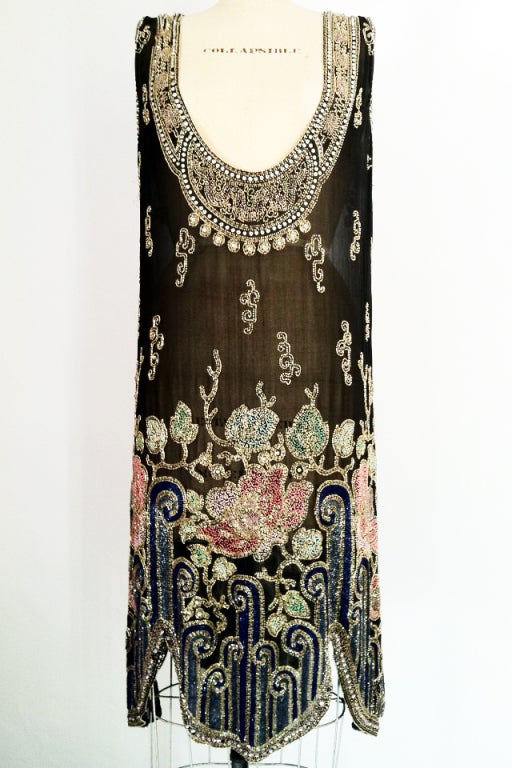 A rare and exquisite beaded flapper dress. Fine sheer black silk item features elaborately art deco beaded neck and hemline. An original unlabeled survivor that is structurally intact with very slight/minimal bead separation and or loss (none