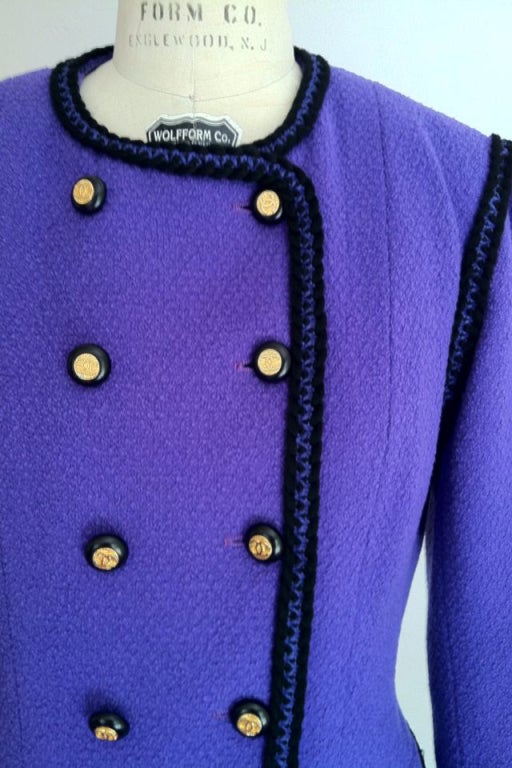 A rare and early Karl Lagerfeld interpretation of the iconic Chanel jacket! Vibrant purple wool fully silk lined with contrasting black braided trim. Eighteen gilt metal/black resin signature buttons.