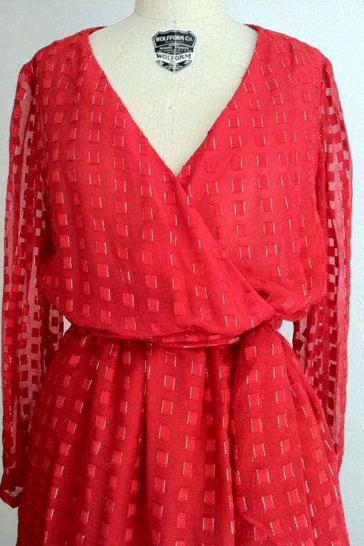 A fine and rare vintage Christian Dior Haute Couture cocktail dress. Gorgeous vivid red and gold metallic silk chiffon item beautifully tiered and draped. Wrap tunic top features original matching fabric sash belt with wrap front skirt. Zippered