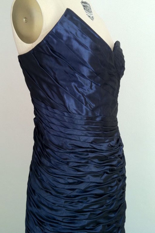 An exquisite and rare vintage Emanuel Ungaro 'mermaid' gown. Fine dark blue silk moire taffeta item fully lined and zips up back with a boned bodice. Item beautifully ruched with an asymmetrical bustline, mermaid skirt and large attached bow!