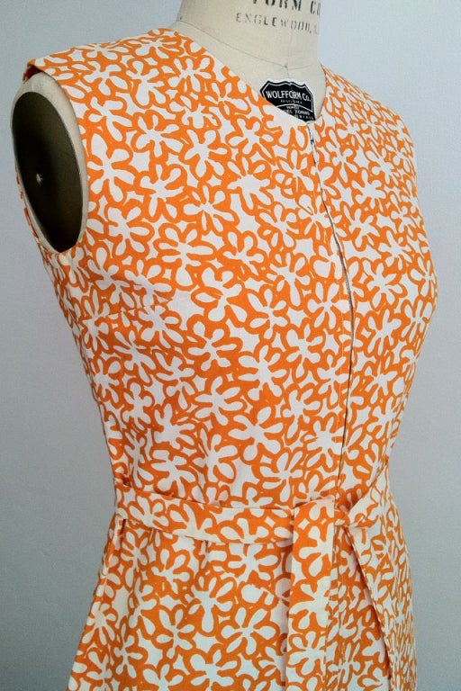 A fine and rare vintage Marimekko dress. Sleeveless cotton printed item features a pointed hemline, zips up front and includes matching belt. A charming example appropriate for any collection or archive.