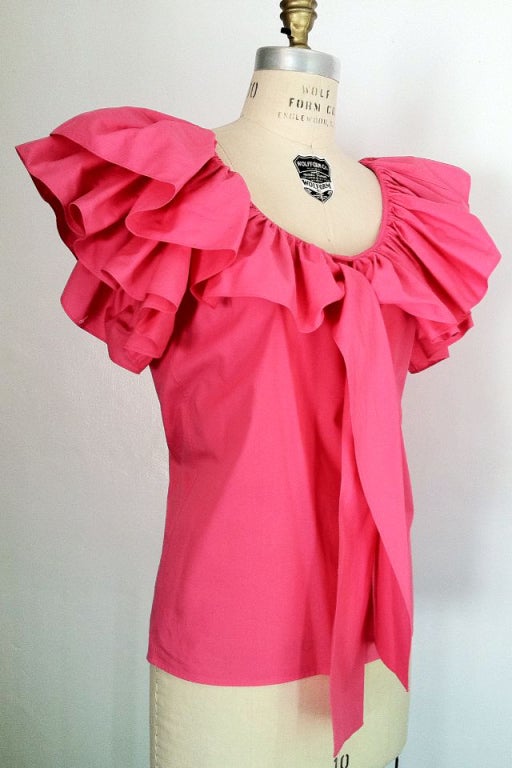 A fine vintage Yves Saint Laurent peasant top. Pink cotton fabric item features pleated collar and short sleeves with attached matching fabric ties at neck. Item slips over head (no closures).