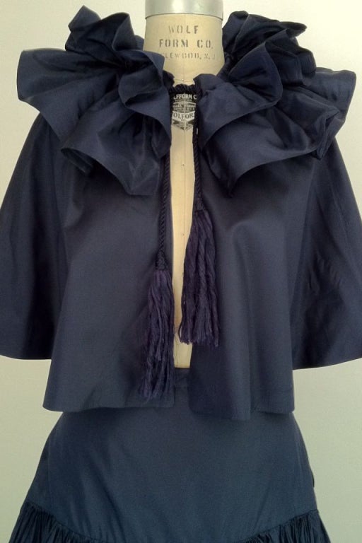 A fine and rare vintage Chanel 2pc. ensemble. Exquisite midnight blue silk taffeta items include a ruffled capelet with drawstring tassel ties and drop waist pleated skirt. Skirt features a generous 