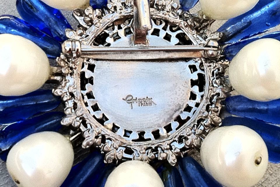 Impressive and extremely rare signed Maison Gripoix pendant brooch. Large silver tone metal floral item with deep rich blue glass 'knobs', cabochon center and faux baroque pearls. Swarovski crystal surround completes theme. Rare signed item made in