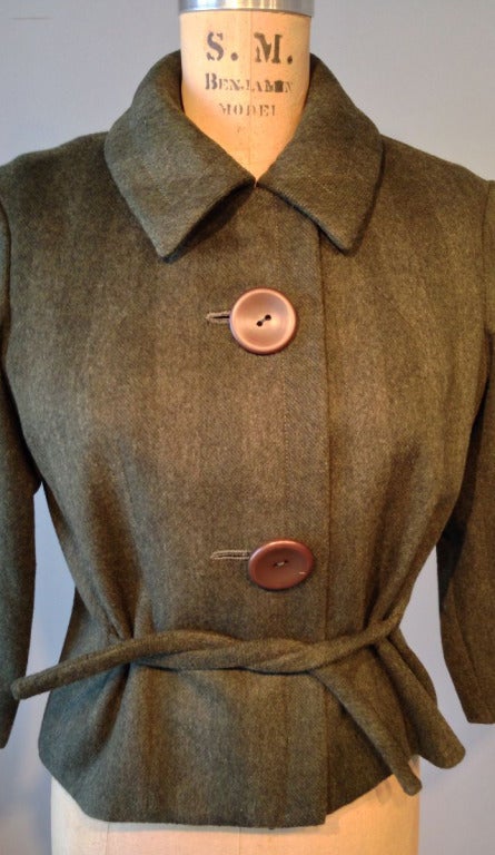 A fine and rare vintage Pierre Cardin Haute Couture jacket. Boxy olive green wool fabric item features a button and tie front. Item fully silk lined.