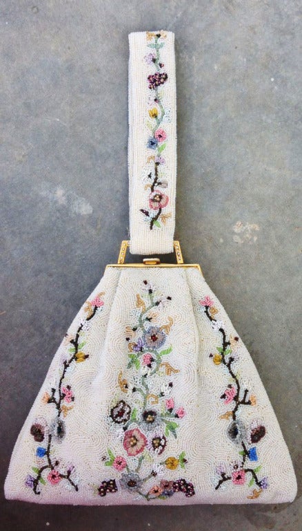 A fine and rare vintage micro-beaded evening bag. Exquisite item and technique. Gilt metal crystal set frame features a ivory silk interior. Appears unused.