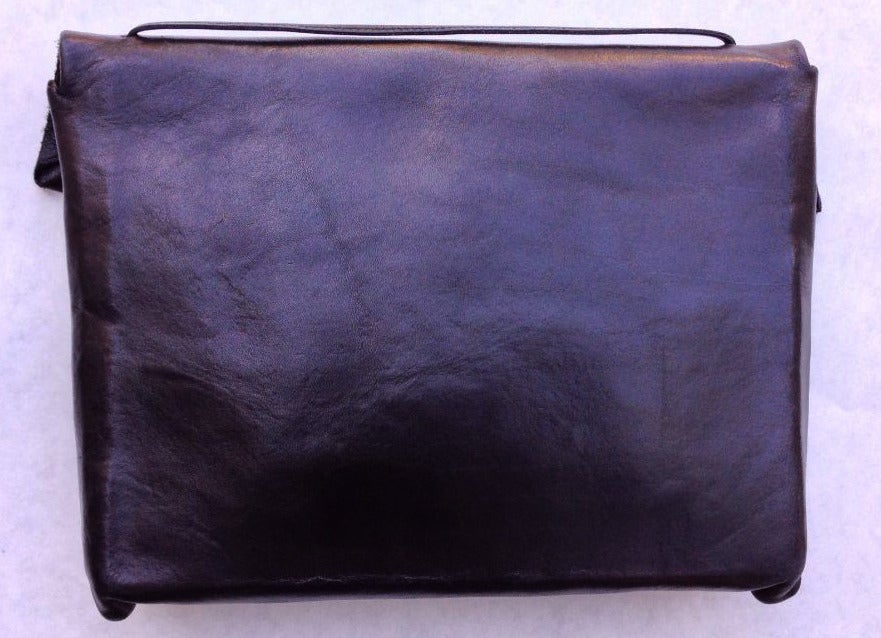 A fine vintage sculpted leather clutch handbag. Molded and sculpted black leather item features a fold-over snap closure and 