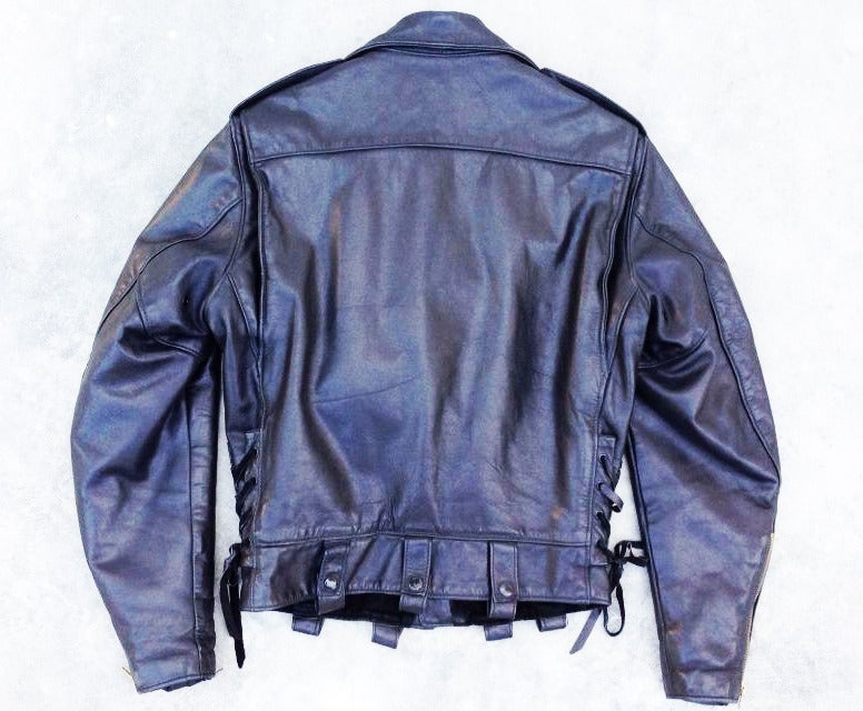 A fine and rare vintage Golden Bear motorcycle jacket. Supple black leather item features a quilted lining, zipper and snap closures and lace tie sides.
