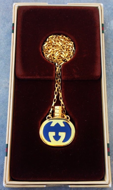 A fine, rare and unused Gucci scent bottle pendant and chain. Gilt logo Lucite embedded bottle attached to matching gilt link 30