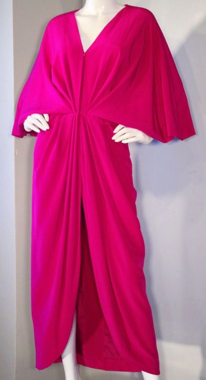A exquisite and rare vintage Jean Patou haute couture cocktail caftan dress. Authentic unworn and hand numbered vivid hot pink silk item features 'kimono' sleeves and hand pleated front with invisible side zipper and hidden hook closures. Waist