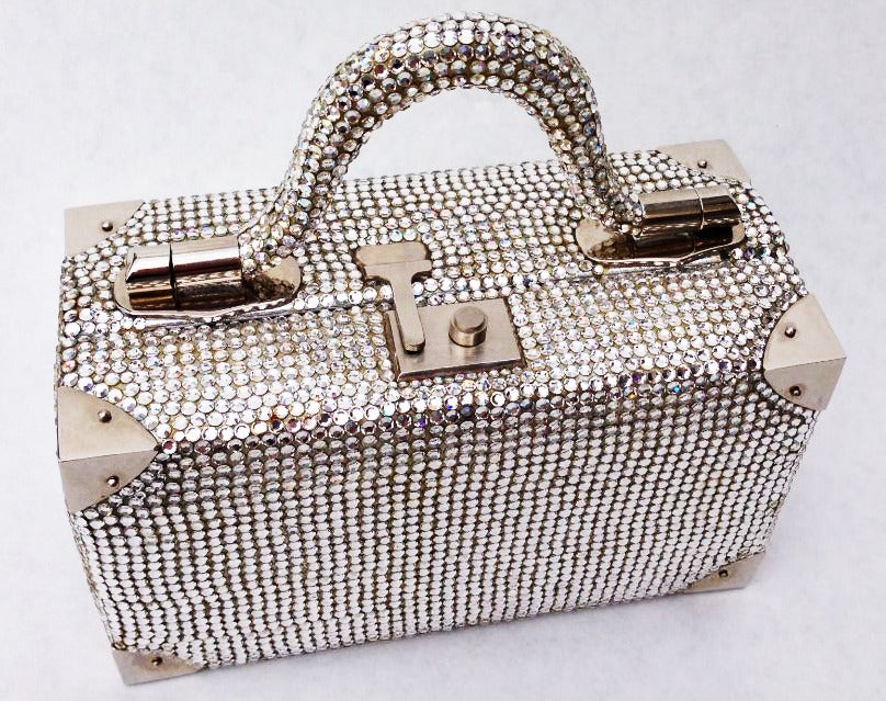 A fine and rare Judith Leiber 'jeweled' handbag. A completely Swarovski crystal covered 'trunk' theme item retains original matching coin purse and information card.