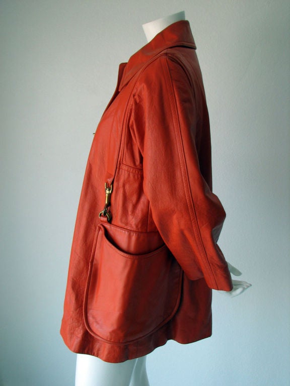Fine & rare vintage Bonnie Cashin leather jacket with attached shoulder bag. Authentic red/orange leather item fully cotton lined with signature brass turn locks. Rare model features attached matching leather shoulder bag with brass hardware.