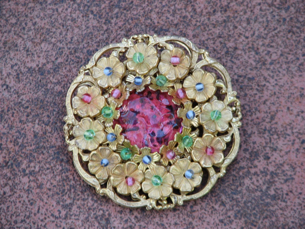 Fine vintage Miriam Haskell brooch. Authentic signed gilt filigree setting with pink 'poured glass' center.