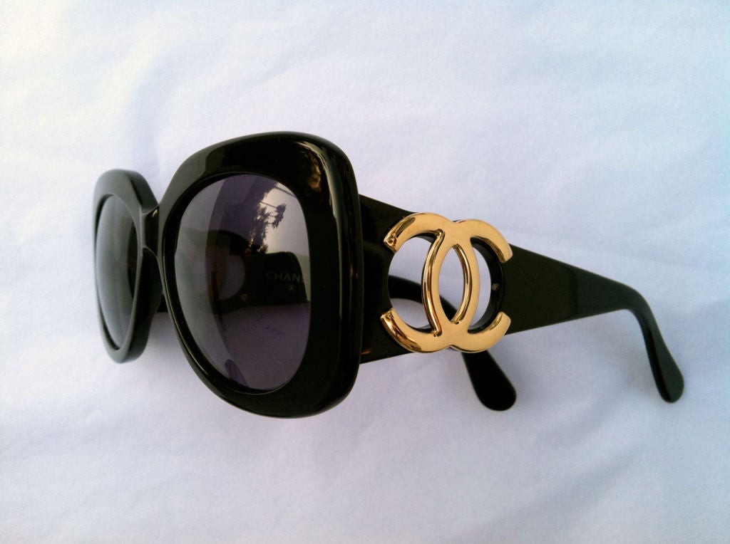 Fine vintage Chanel sunglasses. Heavy black plastic frames with gilt logo cut-out sides. Model 05253 94305.