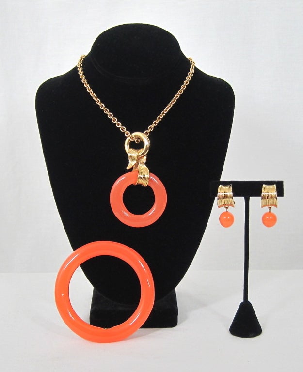 Featured is a beautiful Givenchy matched jewelry set from around the 1970s. Semi-translucent tangerine colored Lucite and striated textured gold tone metal settings. Each piece is marked.

Bracelet: 
8
