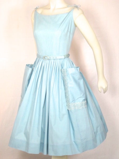 Fantastic  sun resort dress made of wholesome cotton. Ties at shoulder has big pockets with lace applique. Metal zipper and matching belt. Photographed with crinoline not inlcuded.

Bust         38