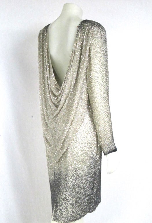 Hands down this is an  amazing cocktail dress! Fantastic draped back ombre silver and Gun metal gray  beading. Zipper in back plus invisible wire with hook to hold dress/drape onto body  Long sleeves. Size 14

Please e-mail us with questions. We