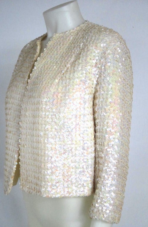 Lovely iridescent sequin perfect white jacket- lined.
Quaint to have the former owner's name inscribed on the inside... Eva Schmir! 

Bust: 40