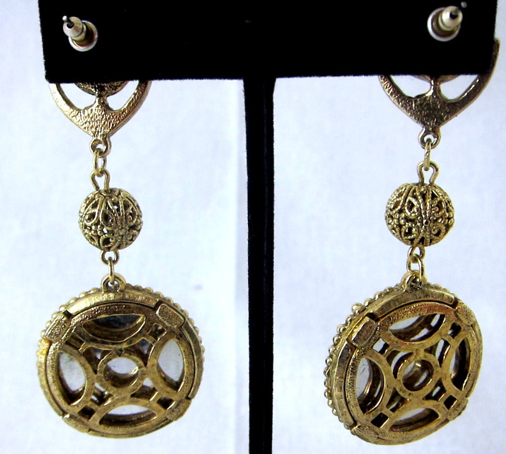 Vintage Byzatine Ornate Gold Metal and blue Glass ,mirrored back. The have a nice solid weight . Pierced Ears.

3