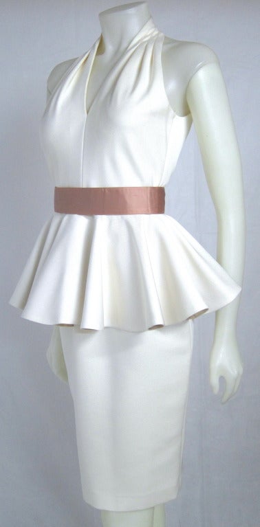 Sexy and oh so lady like! Halter style, keyhole back peplum wiggle dress with mauve color satin  belt. The under side of the peplum is a gold metallic  fabric . Padded Bra cups, zipper in back fully lined . Size 4

Bust: 34