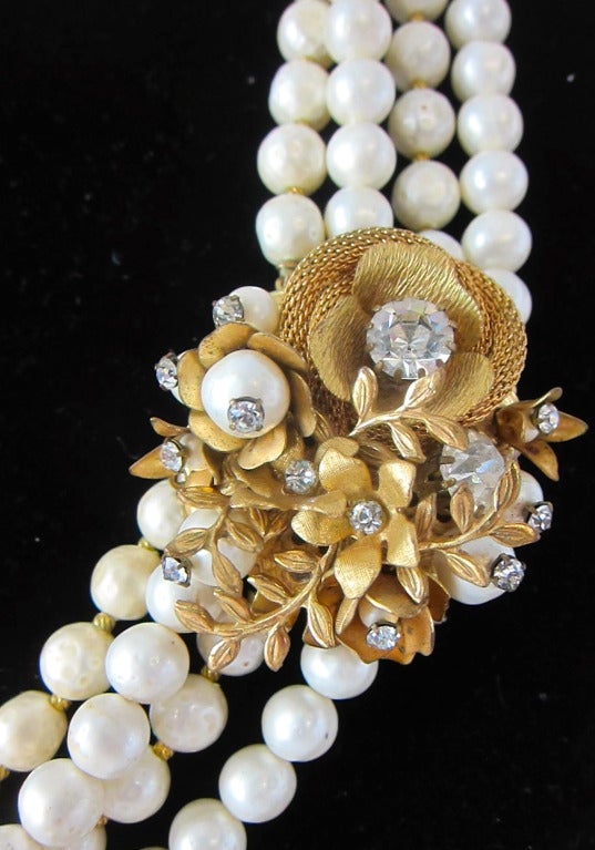 Gorgeous multi-strand faux pearl necklace. It has the famous Miriam Haskell Gold flowers, pearls and rhinestone closure which converts to a brooch. So you can wear the brooch separately without the pearls. Nice and lightweight and perfect for a