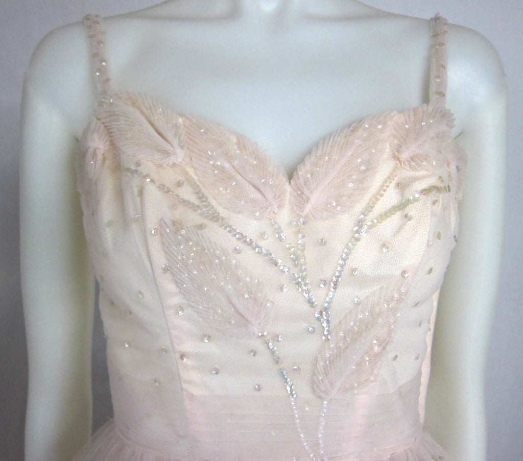 Very rare 1950s True Gala Formal Dress. Palest of pink in color almost buff. The details of hand made leaves and sparkles on the bodice are incredible. The sparkles fall to the side sash of the tulle skirt. Layers of tulle and acetate under dress. 
