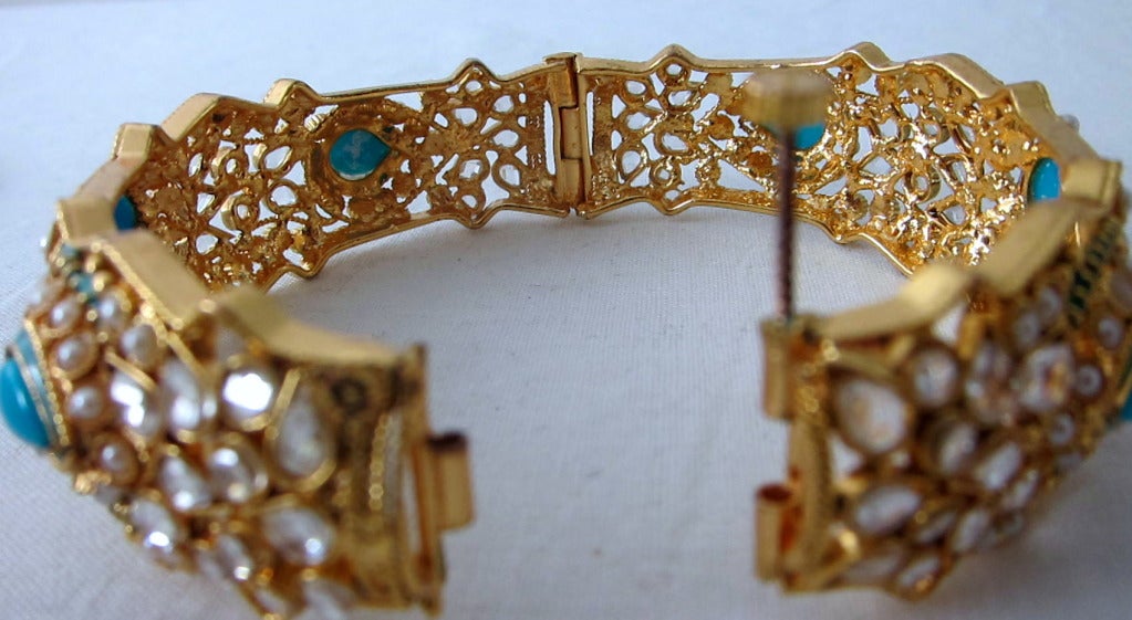 Gorgeous bracelet made of a gold tone metal of intricate design with turquoise thermostat cabochons, faux seed pearls rhinestones. Hinged with screw pin closure.  Cheerful wearing! 

7.5 inch wrist x 1
