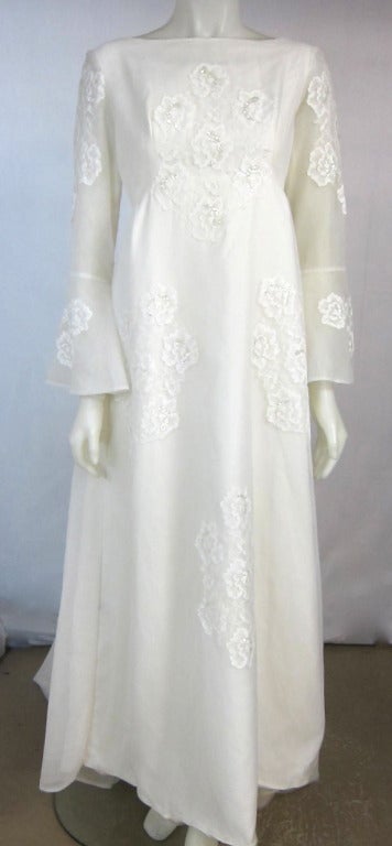 Gorgeous wedding dress from the late 1960s.  Organza and lace applique with rhinestones empire with bell sleeves. Full train, metal zipper. 

Bust: 36