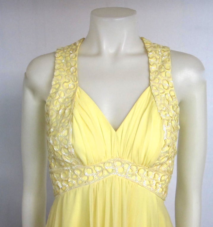 Lovely dress…lovely for a beach wedding or summer gala. Sexy shelf bust and full back of iridescent sequins. Flowing yellow chiffon maxi dress and full lined.

Bust: 32
Empire Waist: 24