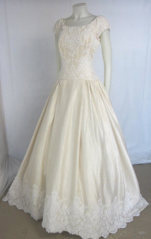 Gorgeous Wedding Dress! Lace bodice, cap sleeves  with zipper back and back buttons and loops. Full gorgeous silk skirt with Scalloped Lace. Huge Train. Flattering waistline. Line and full attached crinoline. 
Bust: 34