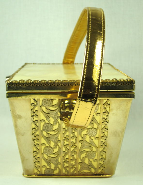 This is a large 1940's gold fancy design metal purse with sea shell top. It has a gold leather handle. The mirror inside is beautifully marred from age otherwise interior is excellent. 
The purse includes original matches from the Lake Merced