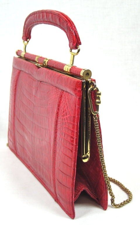 Featured is a fantastic red crocodile purse. It has a detachable chain shoulder strap and it is in beautiful, excellent condition. Made by The Diplomat, Johannesburg S.A. Age unknown.<br />
<br />
Measurements:<br />
8.5