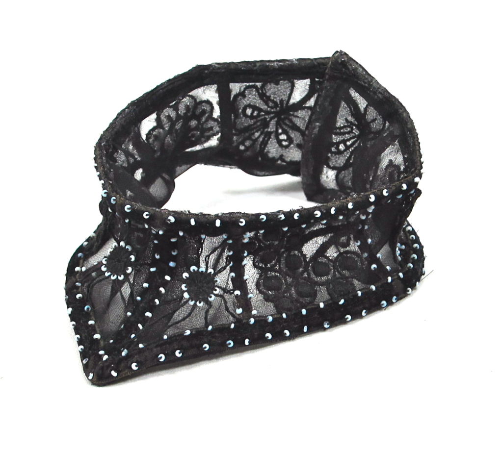 Featured is an exquisite flocked velvet Victorian collar trimmed with cut out lace and beads. Designed to fit snugly around the neck, it is supported with bones and is lined in sheer black chiffon. Over this are floral lace motifs accented all over